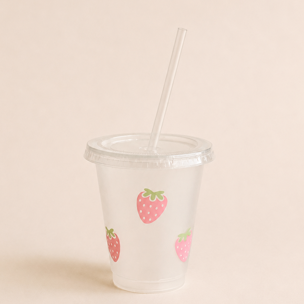 Rosa Trinkbecher mit Erdbeer Design, Deckel und Blumen-Strohhalm mit pinkem Sommerdrink.