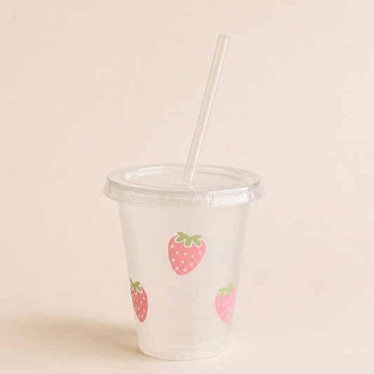 Rosa Trinkbecher mit Erdbeer Design, Deckel und Blumen-Strohhalm mit pinkem Sommerdrink.